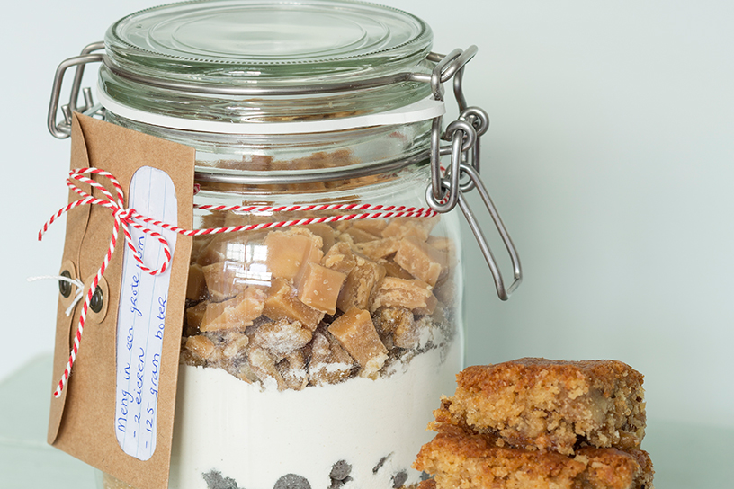 Een weckpot met ingrediënten voor zelfgemaakte karamelcakejes met een leuk kaartje eraan